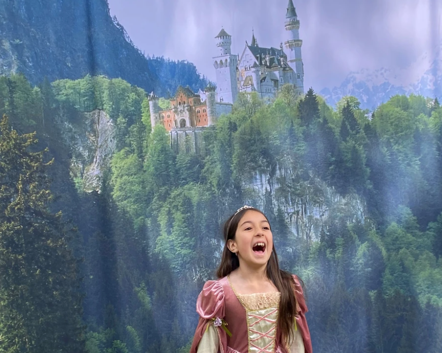 Image of a girl singing infront of an image with a castle
